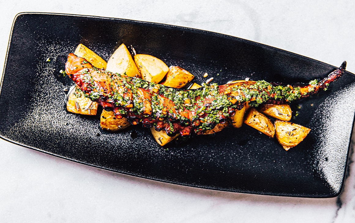 grilled octopus atop potatos