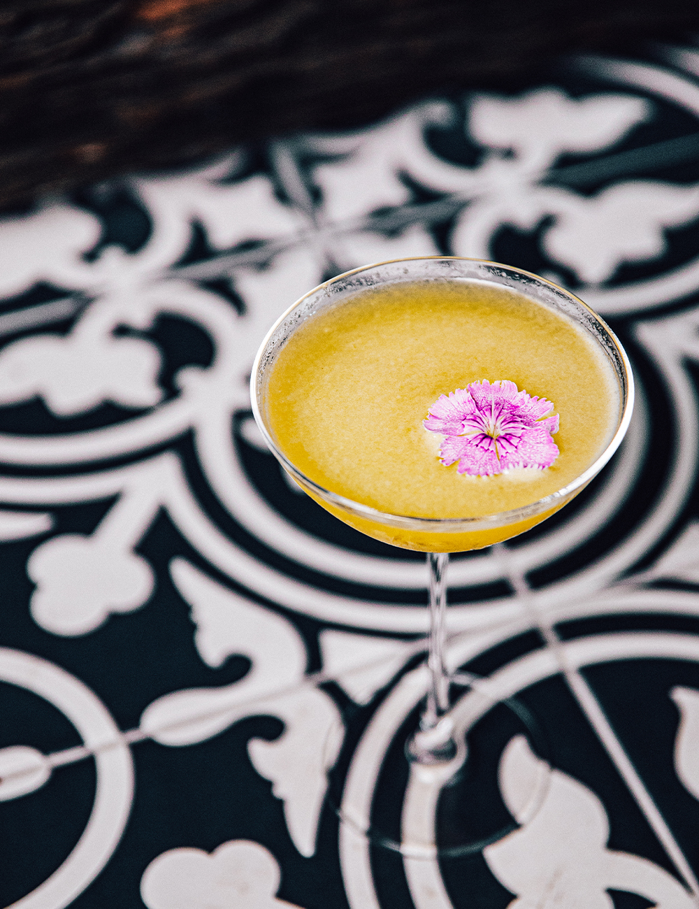 a cocktail on a black and white tiled bench