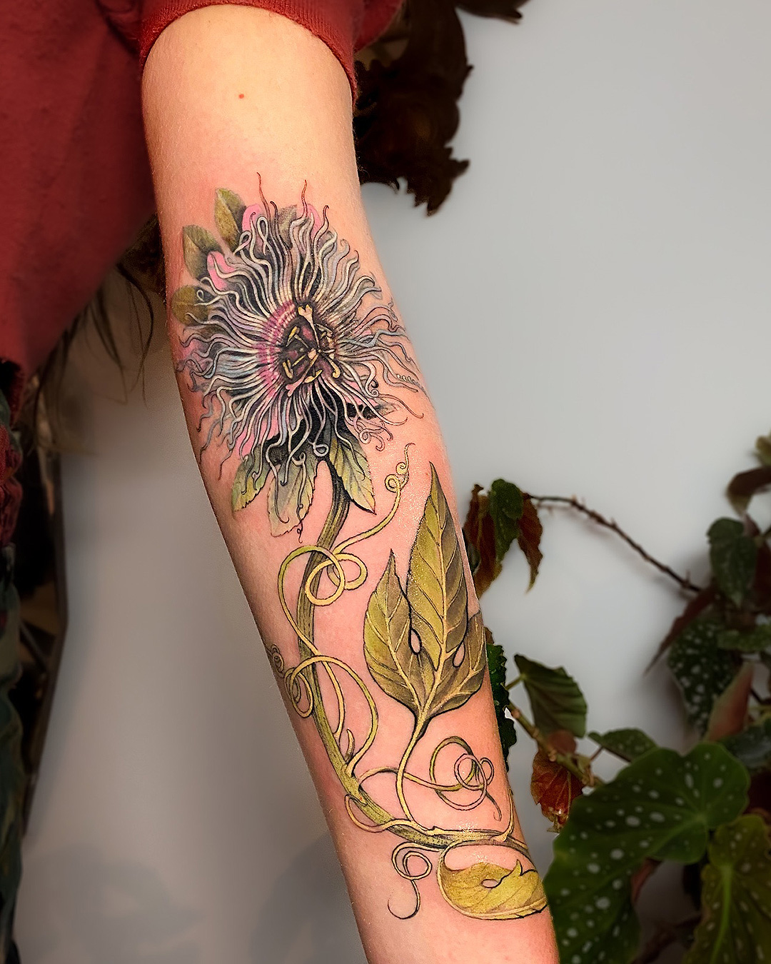 Someone with a trippy flower tattooed on their arm at Exium.