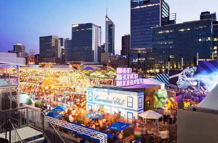 a large outdoor event space lit up in front of the Perth city skyline