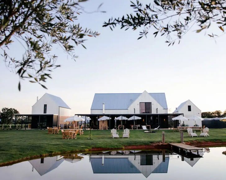 A view of The Vine Loft farm stay with a lake at the front in Mudgee NSW