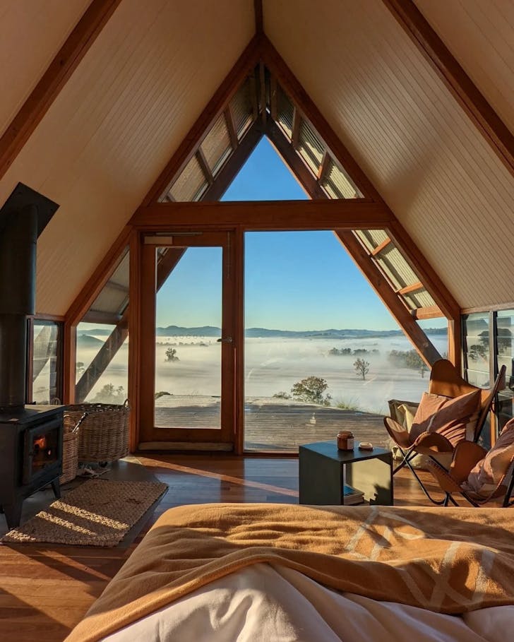 A view of mist-covered fields from the bedroom of a farm stay at Kimo Estate NSW
