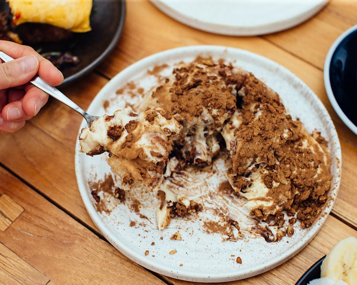 Vicki forks into a giant cinnamon bun at Farm House Cafe.