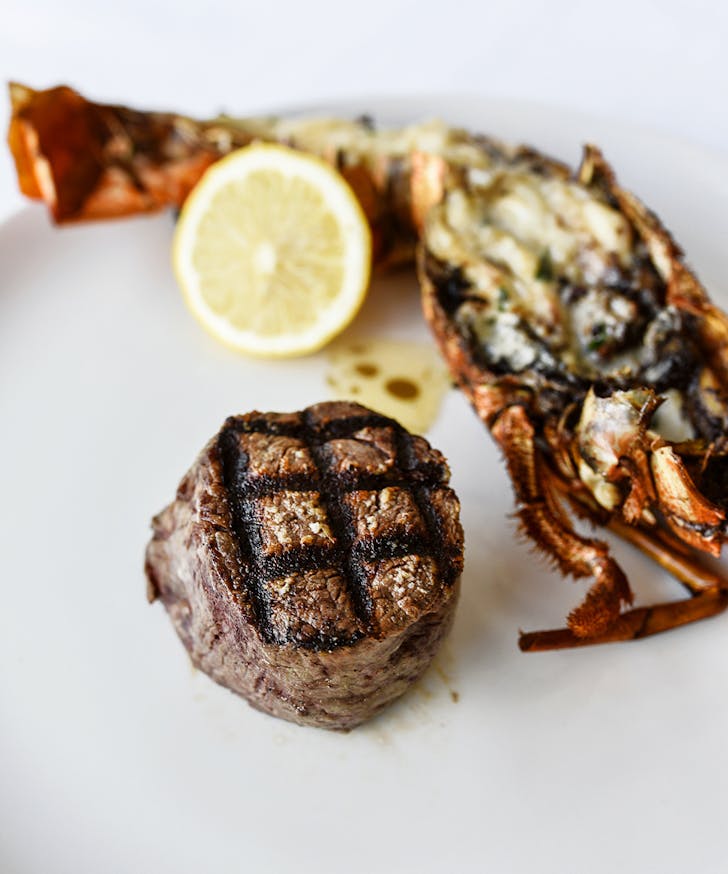 a steak and half a lobster on a plate