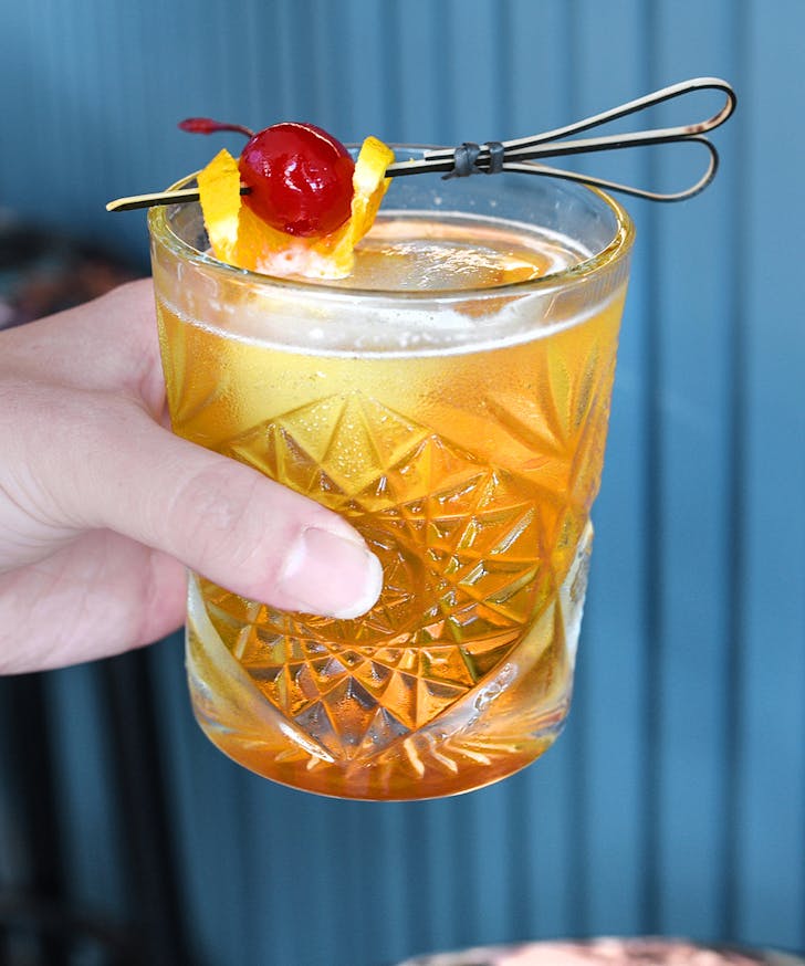 a hand holding a cocktail