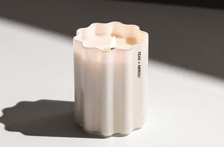 One of the best scented candles in front of a grey shadow.