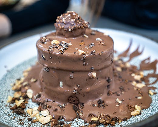 A decadent chocolate cake with a Ferrero chocolate on the top.