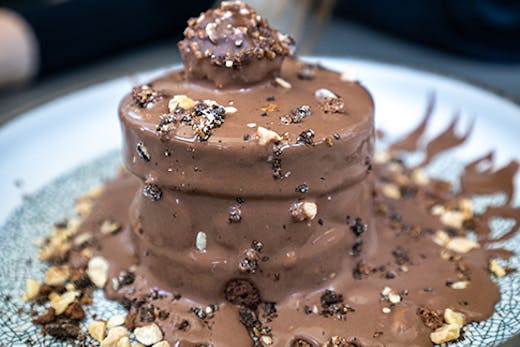 A decadent chocolate cake with a Ferrero chocolate on the top.