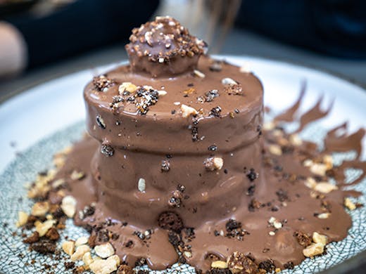 A decadent chocolate cake with a Ferrero chocolate on the top.