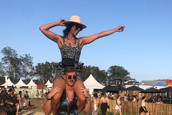 Man and woman on his shoulders at festival grounds