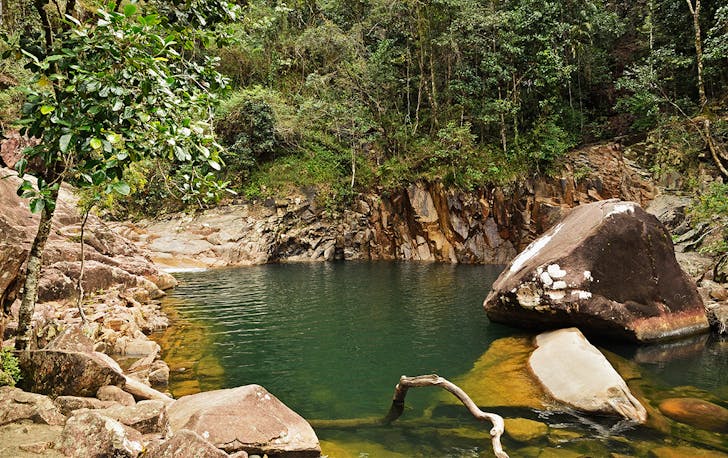 a stunning pool of sparkling water, encased by rocks and greenery