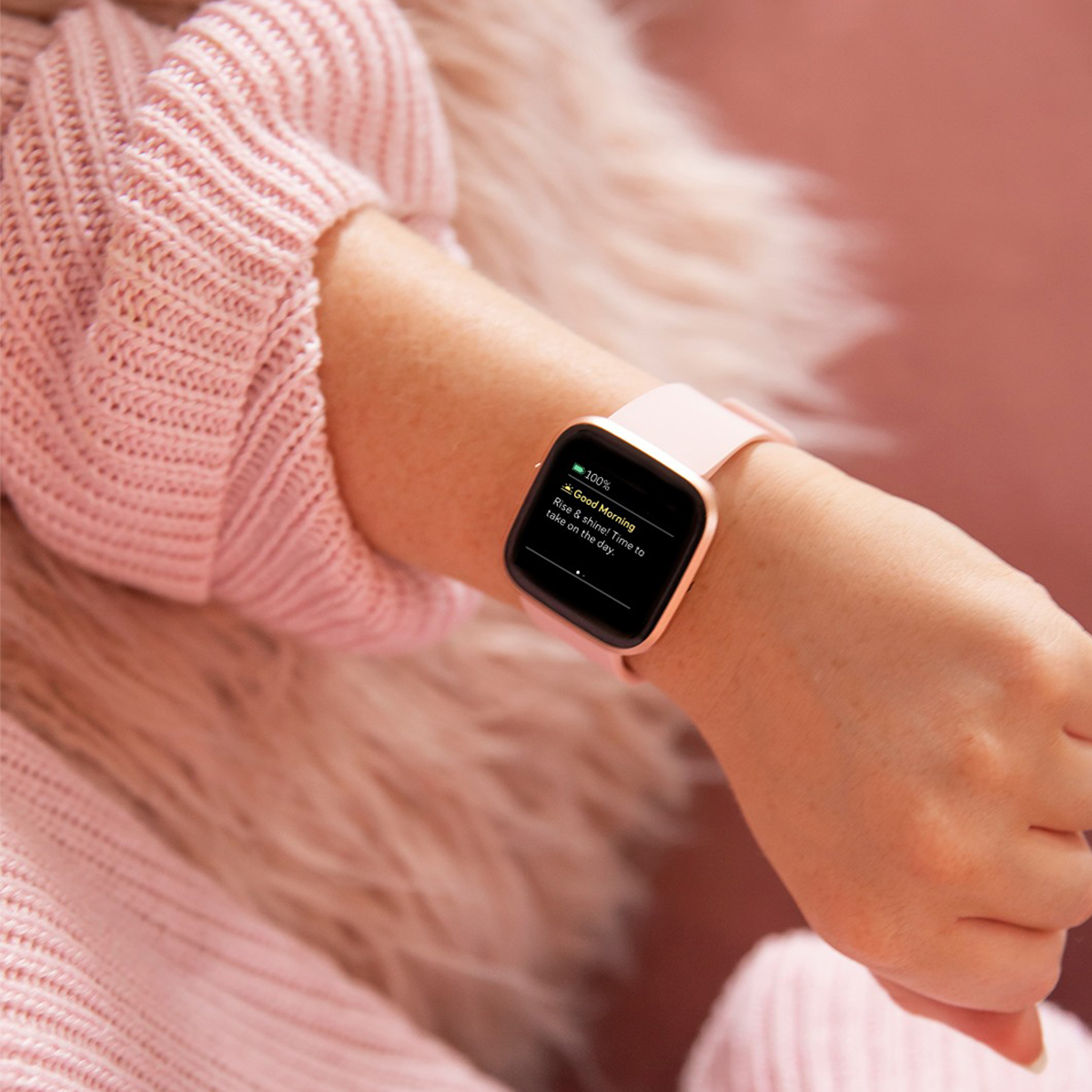 a pink fitbit on someone's wrist