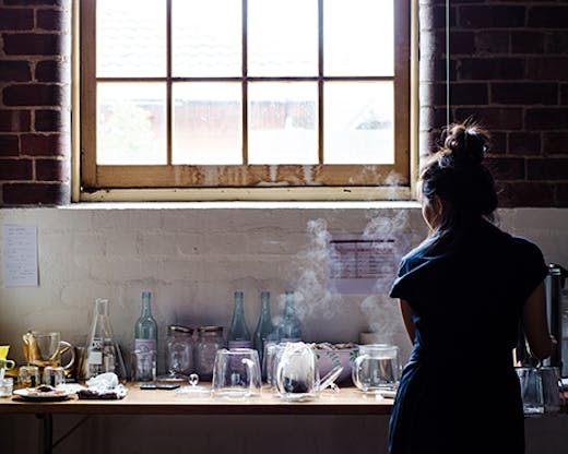 A woman making tea in a warehouse.