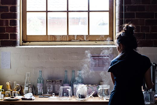 A woman making tea in a warehouse.