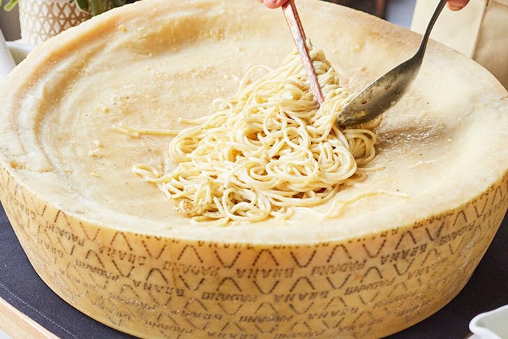 a giant cheese wheel with pasta in it