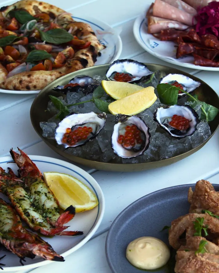 A table stacked with pizza, oysters and prawns at Flinders Street Wharves.