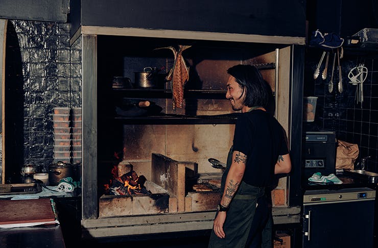 A chef cooking by a hearth at one of the best restaurants in Melbourne for 2023, Flint. 