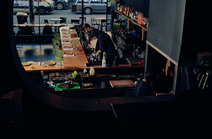 Two people working behind the bar at one of the best restaurants in Melbourne