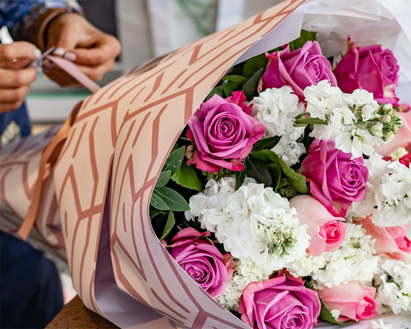 Someone adds the finishing touches to a lovely bouquet from Flowers after hours.