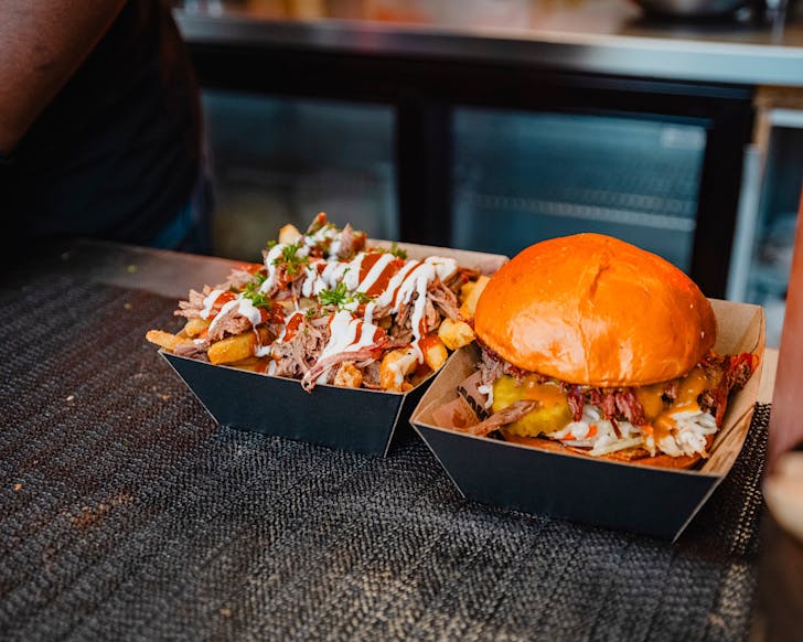 A delicious-looking burger and loaded fries with meat from a Food Truck.
