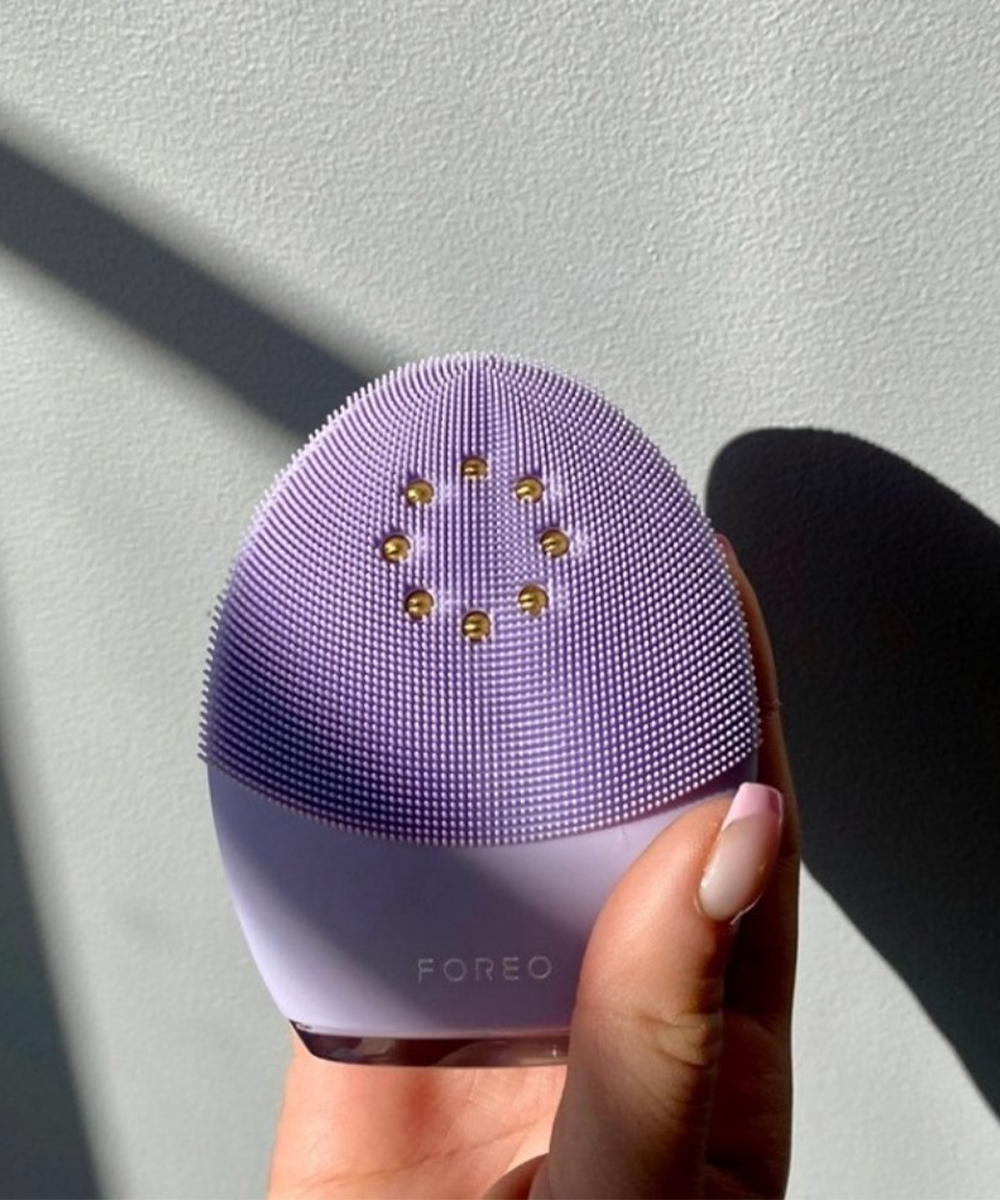 a hand holding a foreo luna device