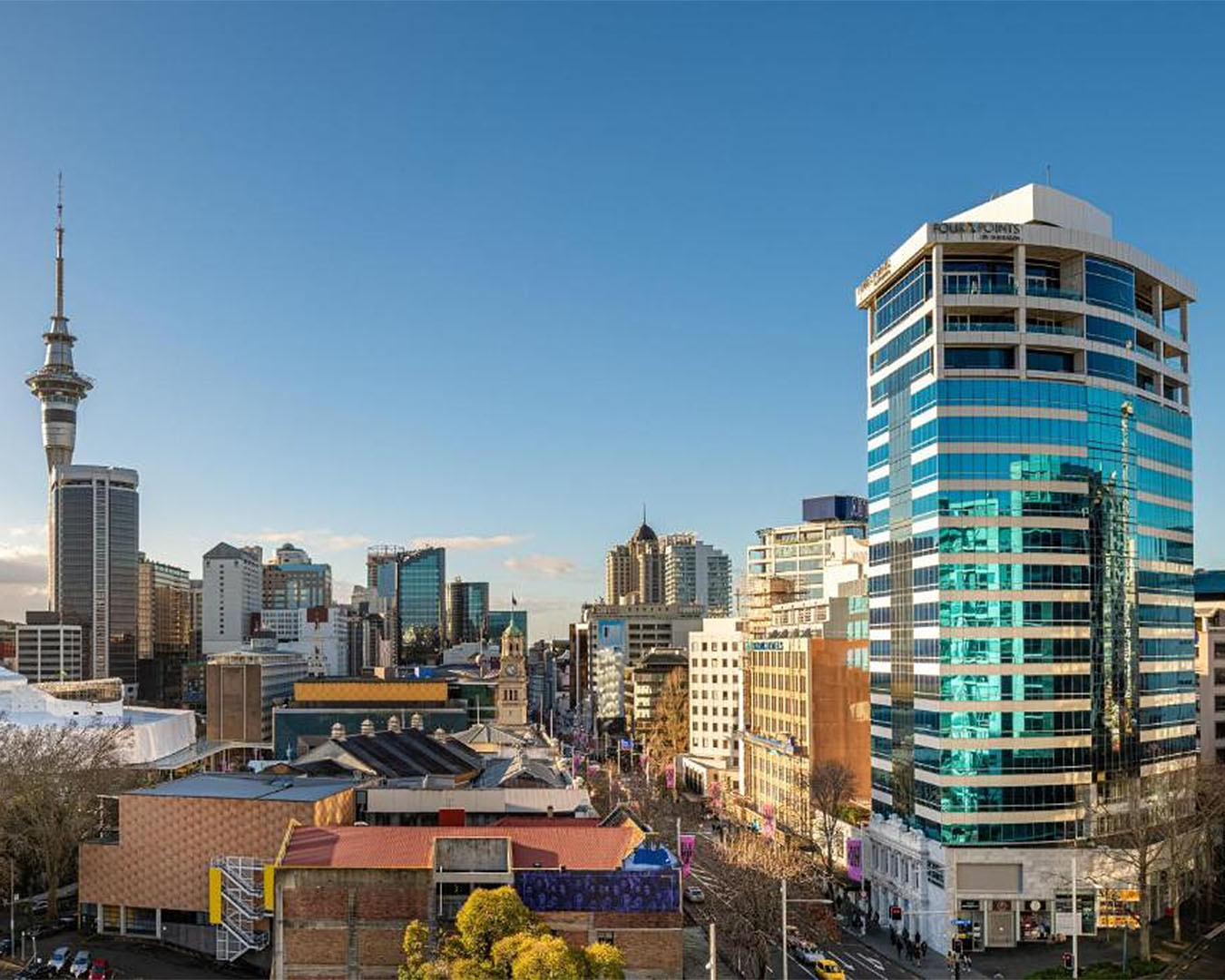 The exterior of one of the best hotels in Auckland, the Four Points By Sheraton dominates the skyline with the Sky Tower in the distance.