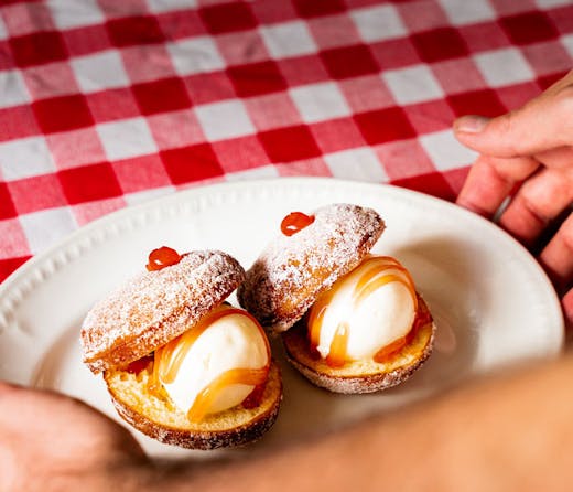 Bombolini ice cream sandwiches on a red and white checked table cloth. 