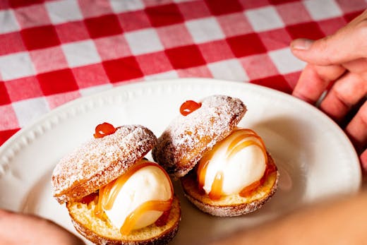Bombolini ice cream sandwiches on a red and white checked table cloth.