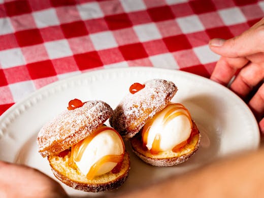 Bombolini ice cream sandwiches on a red and white checked table cloth. 