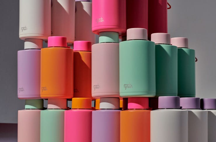 A tower of colourful Frank Green reusable water bottles