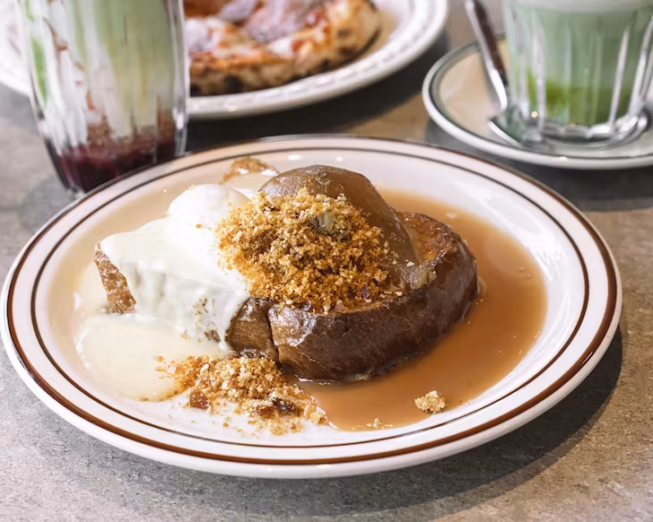 French toast topped with a poached pear, creme anglaise and crumbs. 