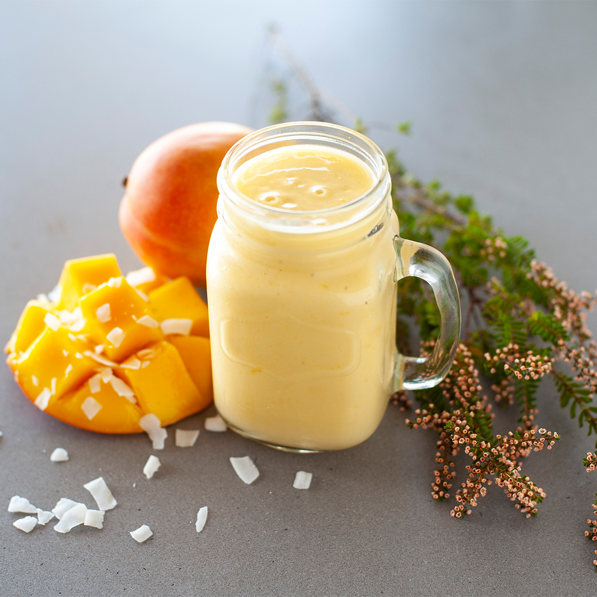 a yellow smoothie in a glass mason jar 