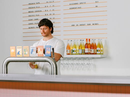 A person pouring beer from beer taps at Freshwater Brewing in Brookvale. 