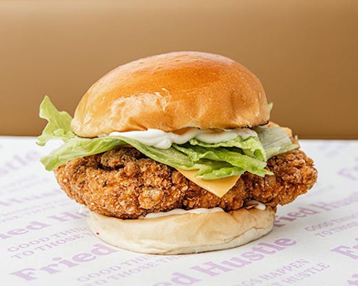 A large chicken burger on old-school serving paper.