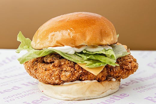 A large chicken burger on old-school serving paper.