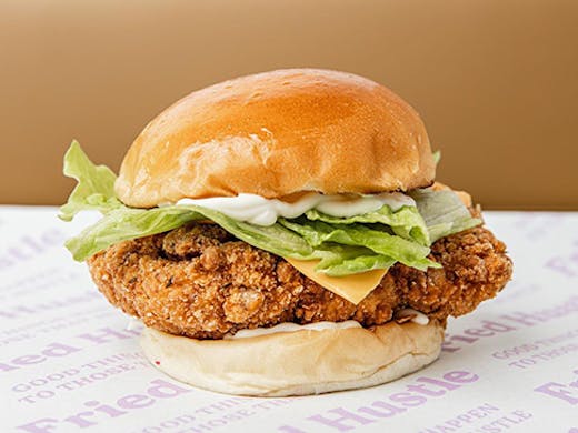 A large chicken burger on old-school serving paper.