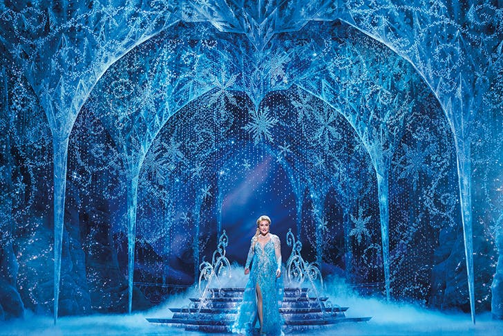 Elsa of Frozen the Musical standing under ice arches.
