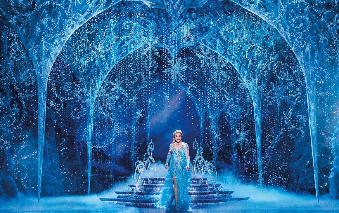 a woman on stage dressed as Elsa from Disney's Frozen