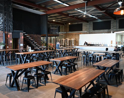 the interior of future magic, with a bar and industrial furniture in a cavernous warehouse space