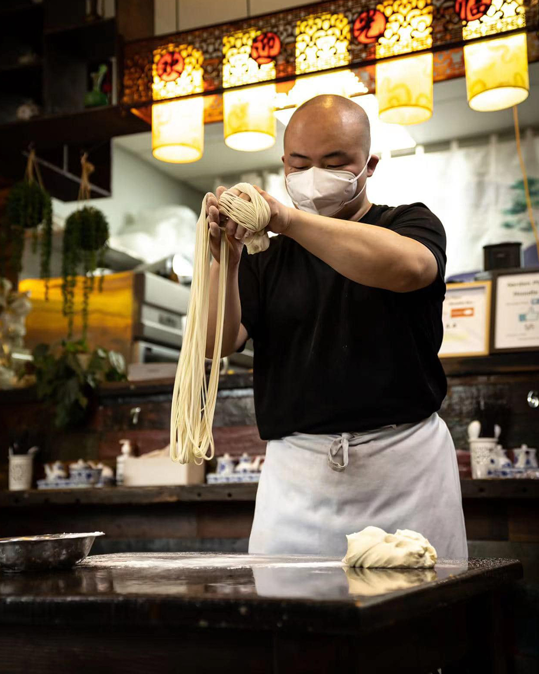 A man hand pulls noodles at Garden Place Noodle Bar, one of the best cheap eats in Hamilton.