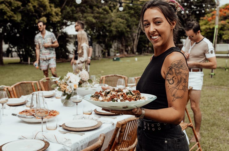 A person holding a plate of salad
