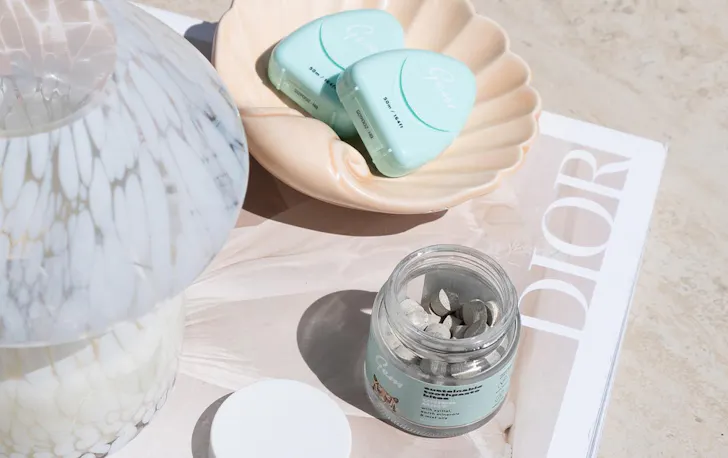 a jar of toothpaste bites and a floss tube 