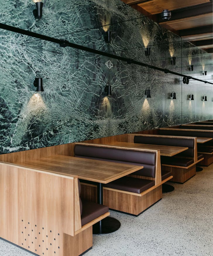booth tables inside a bar with green marble walls