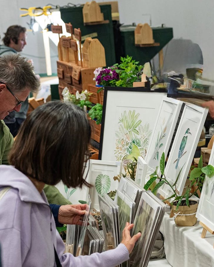 People peruse artwork at a General Collective market.