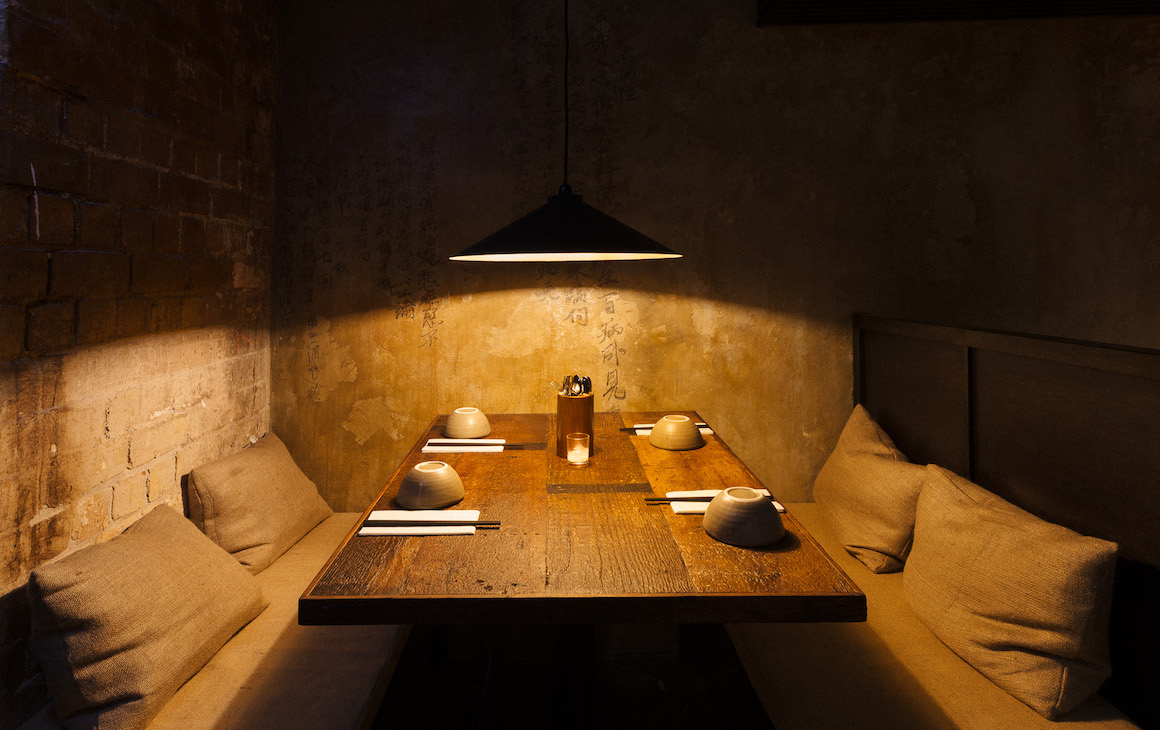 a booth seat with a striking lamp hanging above