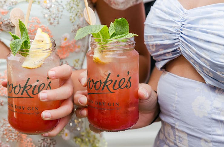 two girls holding gin cocktails in jars