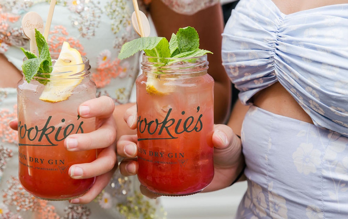 two girls holding gin cocktails in jars