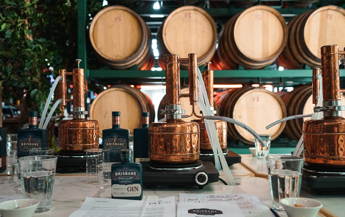 several small copper gin stills on a table