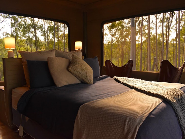 A view of the bed surrounded by nature at Ketchups Bank Glamping one of the best glamping spots in Queensland