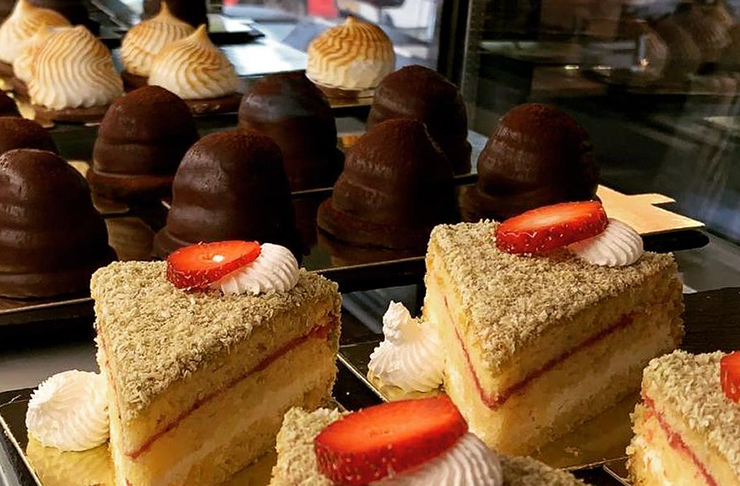 Several gluten free cakes in a cabinet.